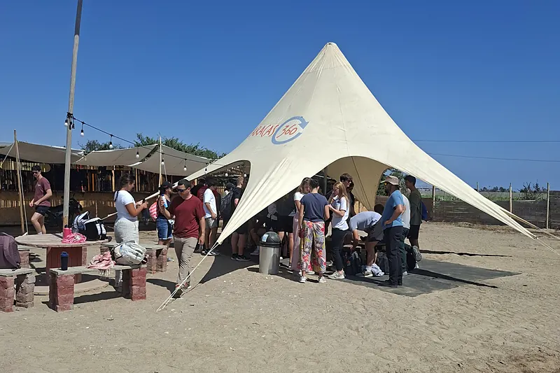 Viajeros reunidos bajo el toldo de la base antes de salir