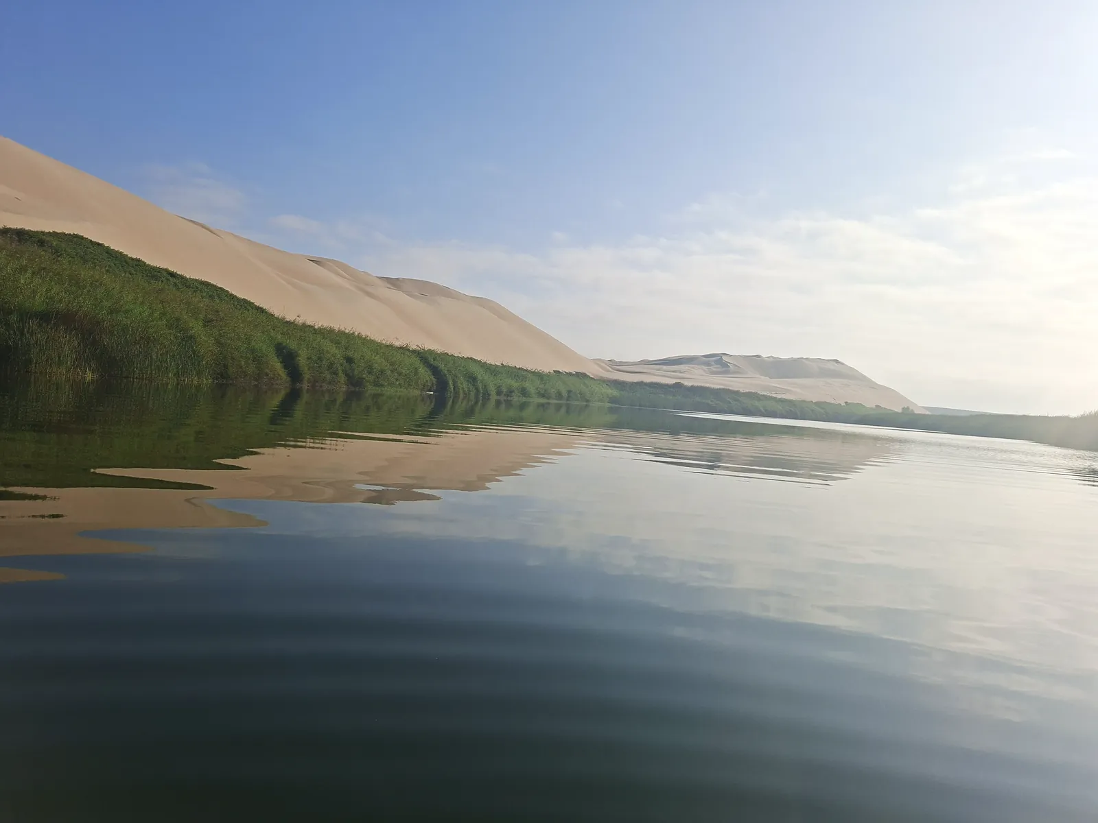 Laguna del Oasis Costa Rica, con la duna y los juncos reflejados en el agua