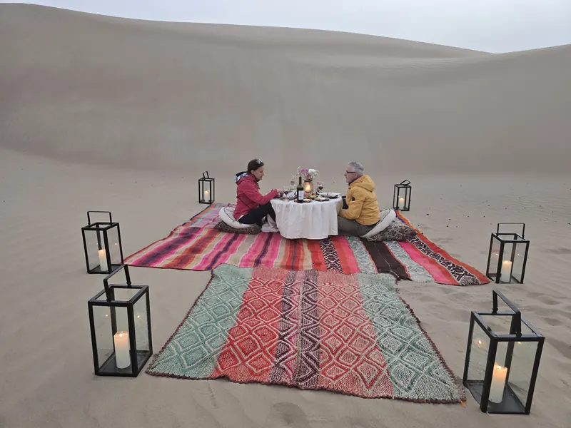 Montaje del Sunset Experience con alfombras y faroles en las dunas